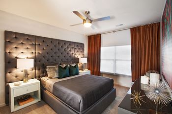 a bedroom with a large bed and a ceiling fan